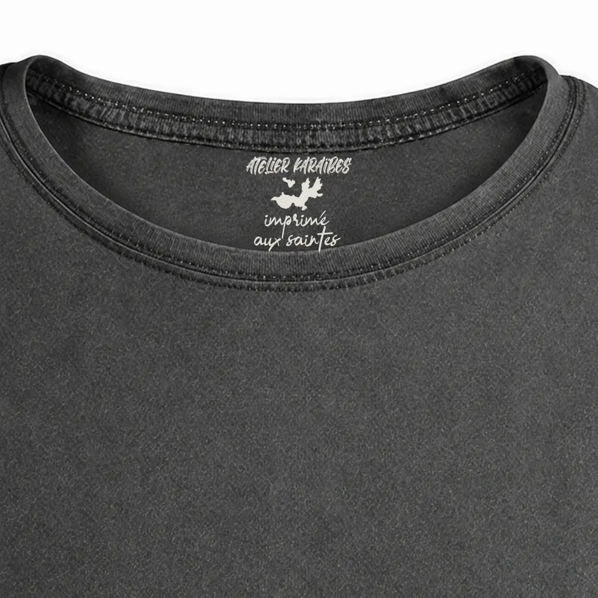 Gros plan de la signature intérieure Atelier Karaïbes imprimée en blanc sous le col du T-shirt vieilli homme gris anthracite délavé
